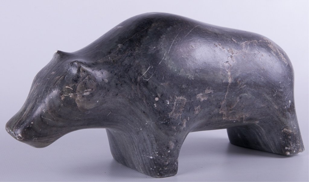 Eskimo Carved Soapstone Bear Sculpture: Eskimo carved grey soapstone sculpture of what appears to be a bear; measures approximately 8" tall, 4-1/2" wide, and 17" deep; in Good condition with slight scuffing and cracking throughout.