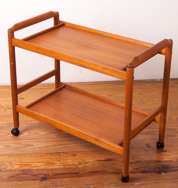 Teak Two-Tier Tea Trolley: Teak two-tier tea trolley on casters; measures approximately 25-1/2" tall to top of handle, 29-3/4" wide, and 15" deep; in Very Good condition.