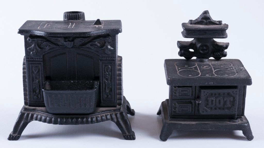 Reproduction Cast Iron Stove Banks, Two (2): Two reproduction cast iron stove banks; largest measures approximately 4-1/4" high. Both are unmarked. Both in good condition, consistent with age and use.