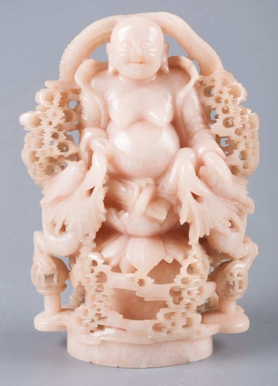 T of 20th C Chinese Carved Soapstone Hotei: Turn of the 20th Century Chinese carved soapstone Hotei, seated on a lotus throne flanked by dragons and carved foliate bower; measures approximately 9" high and 5-1/2" wide.