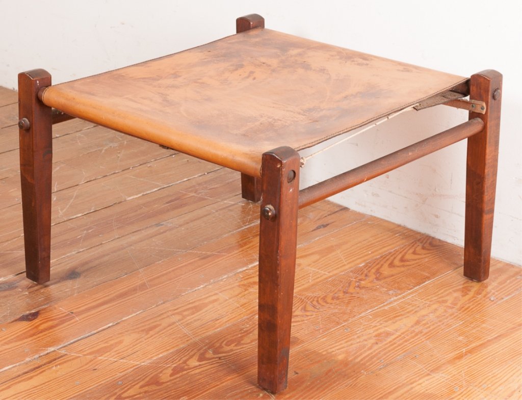 Scandinavian Minimalist Leather Top Footstool: Scandinavian minimalist style leather footstool, having a leather top wrapped and tied over a tapered leg wood frame; measures approximately 15-5/8" high, 24" wide and 23" long. In Good condition, con