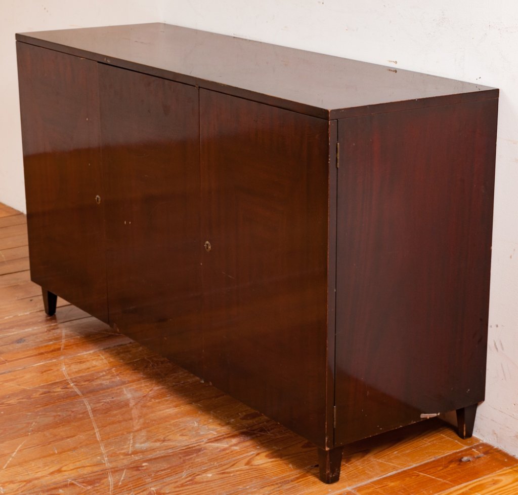 John Stuart Credenza, Three Doors: John Stuart three door credenza with keyhole (key not included) accents opens to reveal three drawers behind the outside left and middle doors and an adjustable/ removable shelf behind the right door;