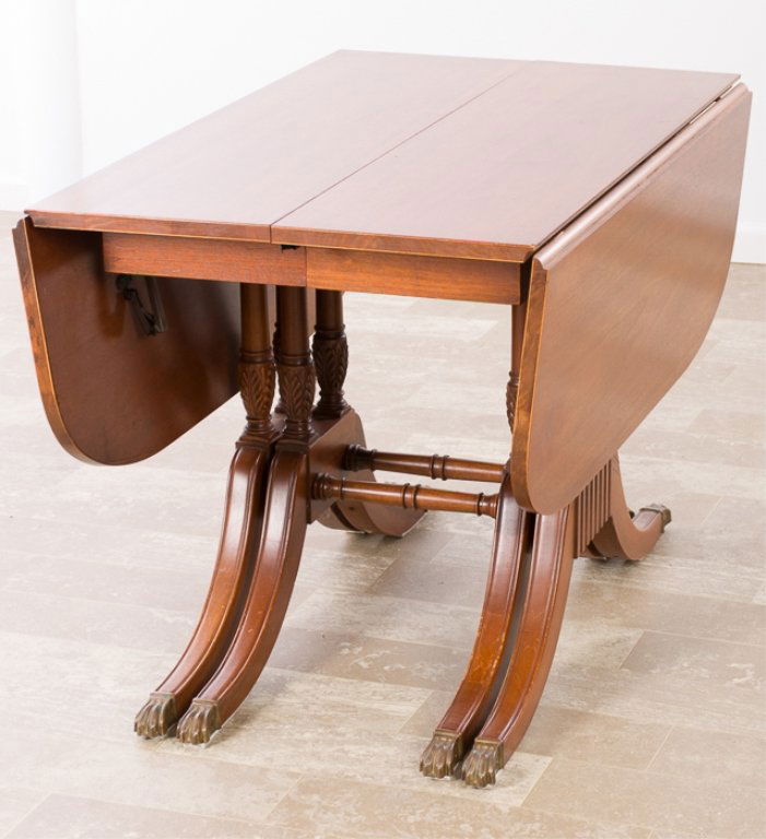 Duncan Phyfe Style Mahogany Dining Table: Duncan Phyfe style mahogany dining table with three leaf insert, drop leaves, eight legs expanding with inserts and brass paw caps to the feet; measures approximately 28-5/8" high, 42" wide and 25-3/8