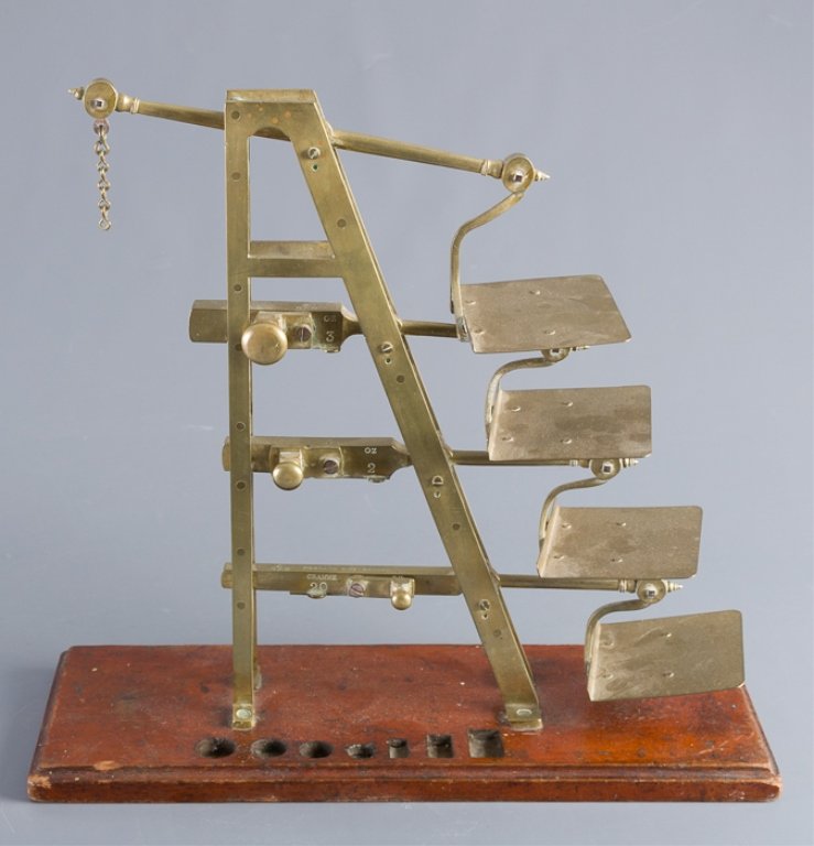 Degrave & Co., London Brass Postal Scale: Unusual brass English Postal scale marked "Degrave & Co. London" mounted on a wood base; measures approximately 15"high, 16" wide and 5-3/4" in depth. Marked to scale arm. Missing counter weight and w