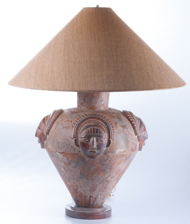 Pottery Table Lamp by Casual Lamps: Large contemporary pottery lamp decorated with relief ethnic masks and having a burlap shade; measures approximately 30-1/2" tall and 26" in diameter to the shade. Marked on base "Casual Lamps 1989". 