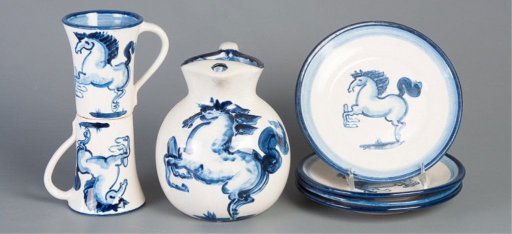 M.A. Hadley "Blue Horse" Pottery Collection: Seven (7) highly collectible pottery items including a pitcher with height of 8-1/2", two (2) mugs with height of 5", & four (4) plates with diameter of 8-3/4". All measurements are approximate. The "