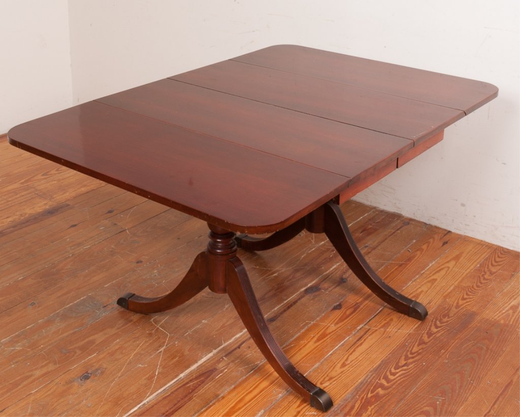 Mahogany Drop Leaf Breakfast Table: Mahogany drop leaf breakfast table with double Duncan Phyfe style pedestals expanding to accept two leaves and having custom pads; table measures approximately 29" high, 38" wide and 54-1/8" in length