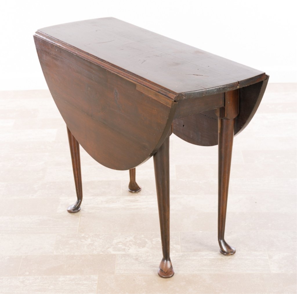 Queen Anne Drop Leaf Gate Leaf Table Circa 18th C: Oval with curved drops resting on gate legs which are block and tapered round and ending in pad feet; measures approximately 26-1/4" high, 36" wide, 13-5/8" in depth without leaves extended and 39-1/2