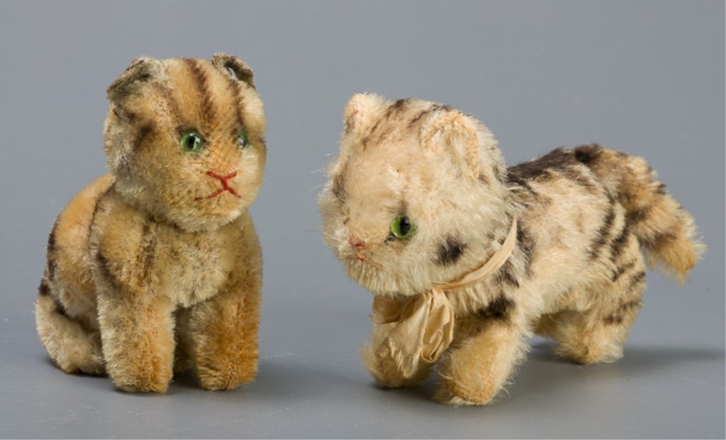 Vintage Early Steiff Plush Tabby Cats: Two tiny and early plush tabby cats, no tags, with glass eyes. One cat has an articulating head, the other is missing a glass eye; largest measures approximately 3-1/8" high and 5-3/4" long.