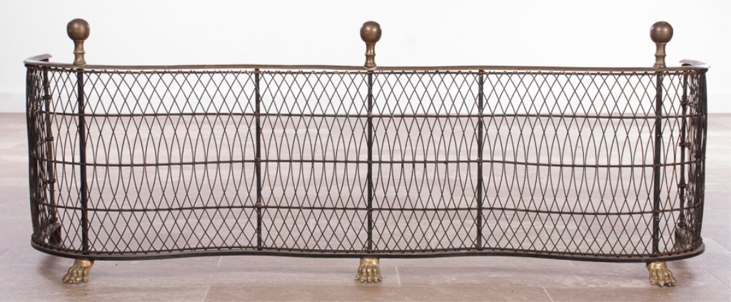 Federal Style Brass and Wire Fireplace Fender: Federal Style fireplace fender featuring a brass and wire serpentine front decorated with ball finials and raised on three paw feet; measure approximately 15-1/2" high, 42-1/4" wide and 11" in depth.