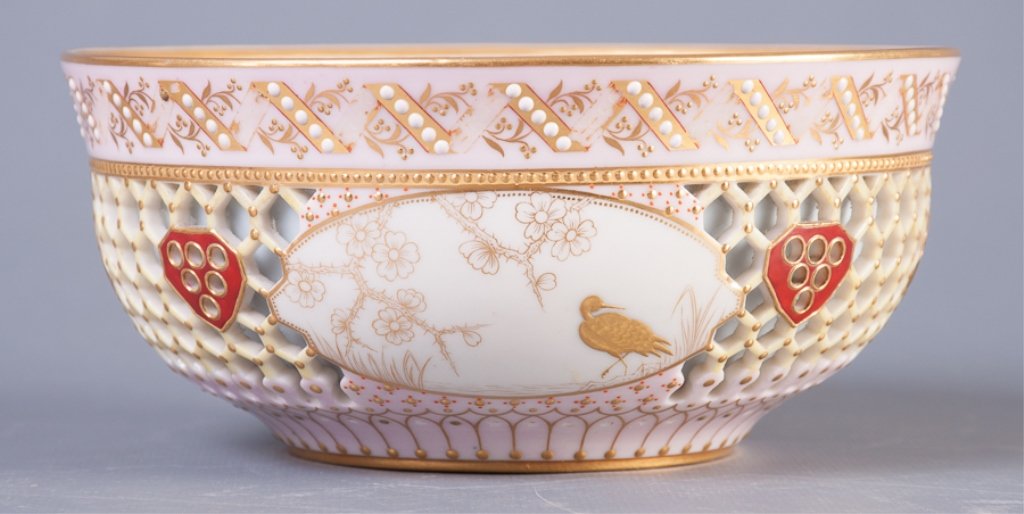 Royal Worcester "Caged" Porcelain Bowl: Royal Worcester double wall bowl, the outer wall reticulated with reserves of gilt bird designs and allover enameling and gilt designs. Measures approximately 2-7/8" high and 6-1/4" in diameter.