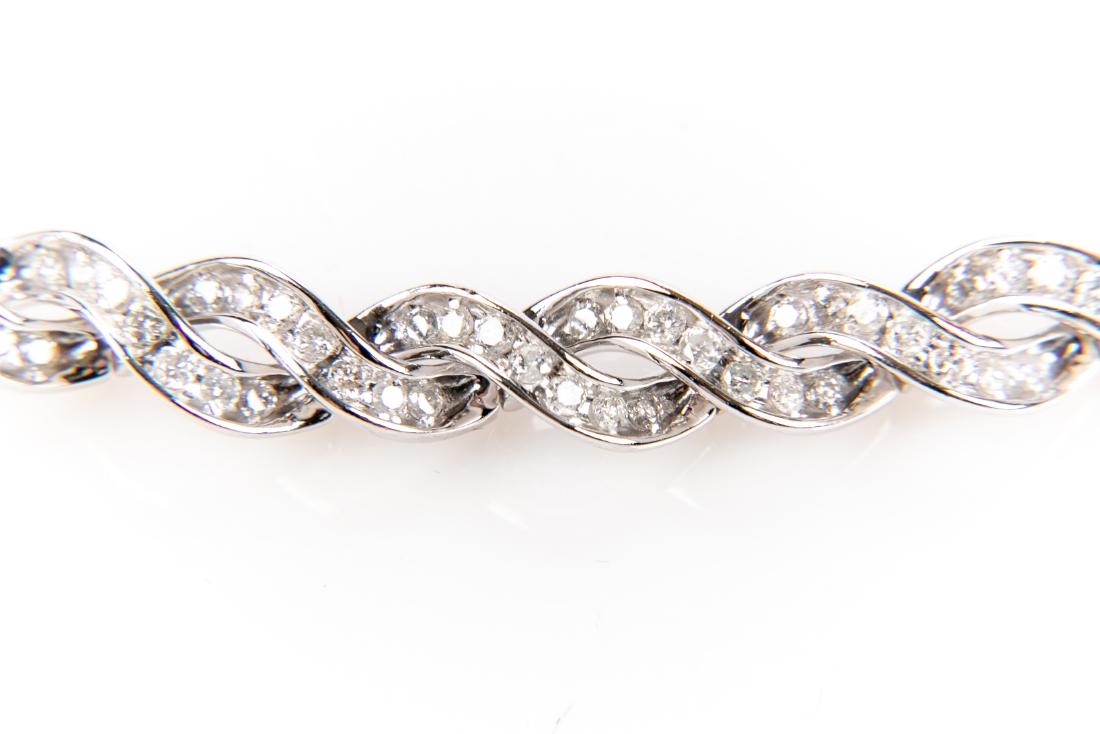 14K Gold And Diamond Bracelet: A fine 14K white gold flexible hinged chain bracelet. Diamonds: 3.8 TCW - 153 channel set, brilliant cut diamonds, each measuring approximately 1.8mm; G - I. Marks: 14K 3TW Measurement: 6 3/4" long x 