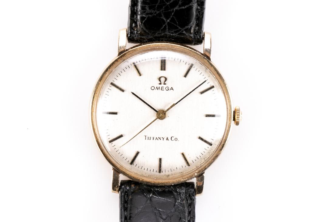 Gold Wristwatch For Tiffany & Co, By Omega: A unisex wristwatch retailed by Tiffany & Co by Omega; 14K yellow gold case and black crocodile band. Marks: 14K B&A on case verso. Omega Tiffany & Co on face. Measurement: Face is 1.25" in diameter (