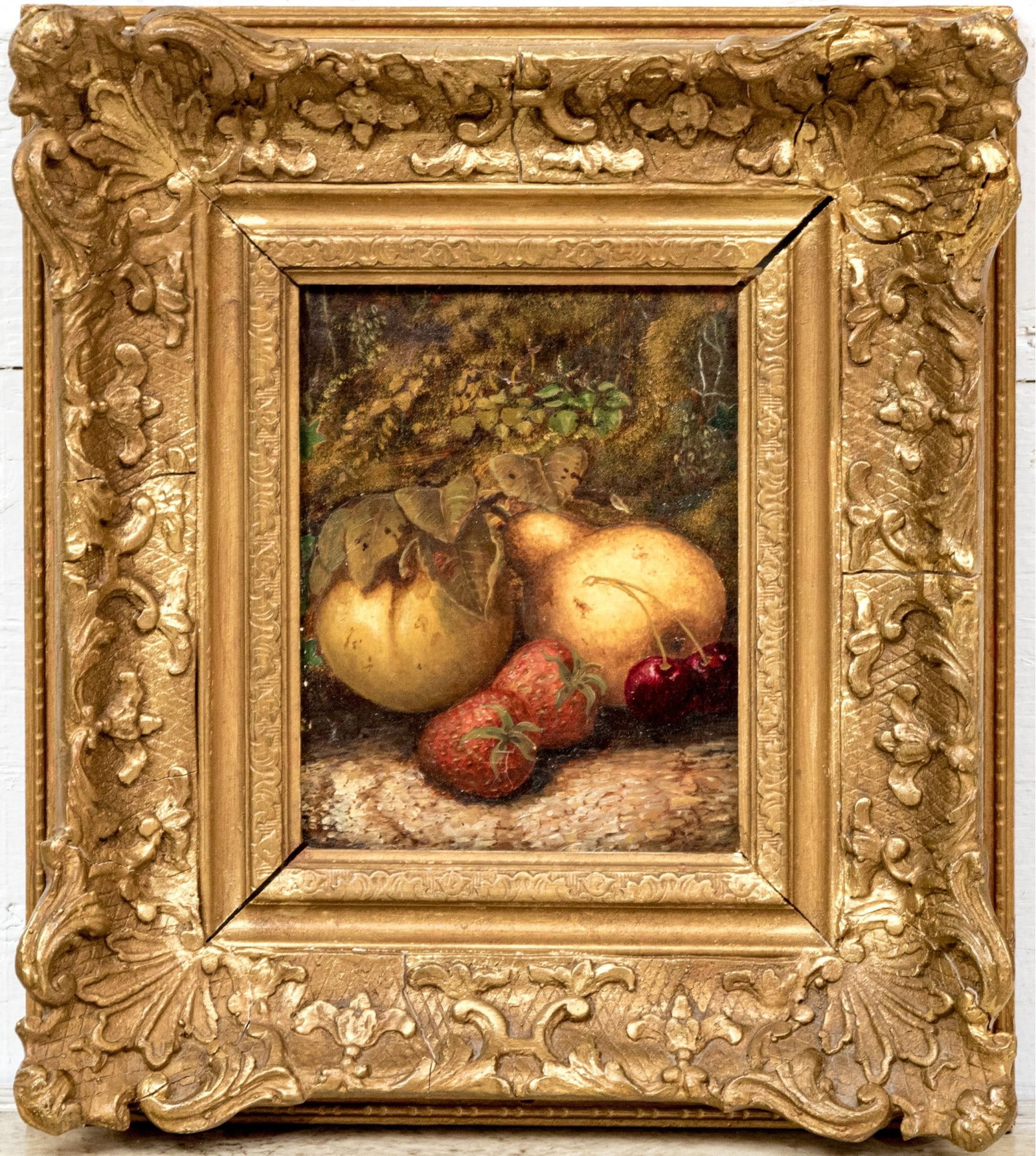 Diminutive Oil On Board, Still Life With Fruit: A lovely and diminutive oil on board painting depicting a still life with group of fruit including two strawberries, two cherries, a pear and apple appearing on a log with greenery in the background. 