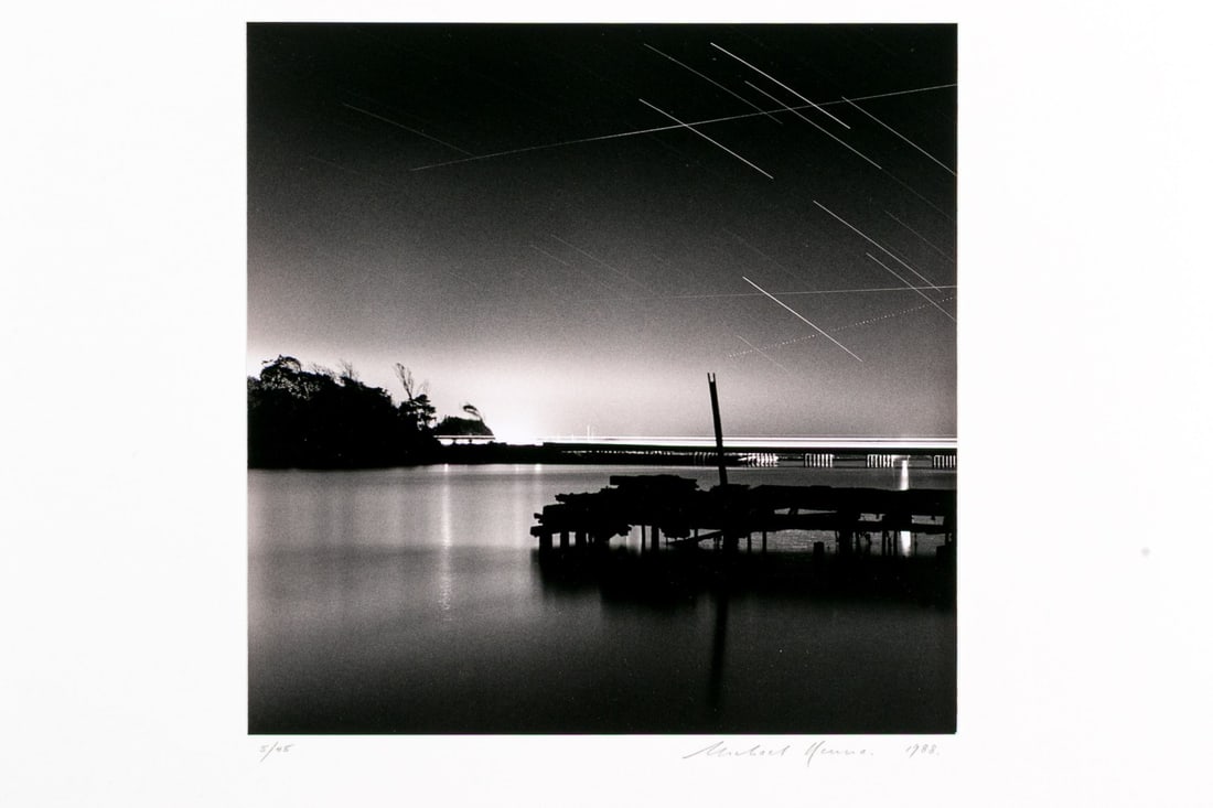 Michael Kenna (British, B. 1953) "Abandoned Oyster Dock" Gelatin Silver Print: Michael Kenna (British, b. 1953) "Abandoned Oyster Dock and Highway One, Moss Landing, California" gelatin silver print depicting a view of a dock silhouette and calm water beneath a starry sky. Signe