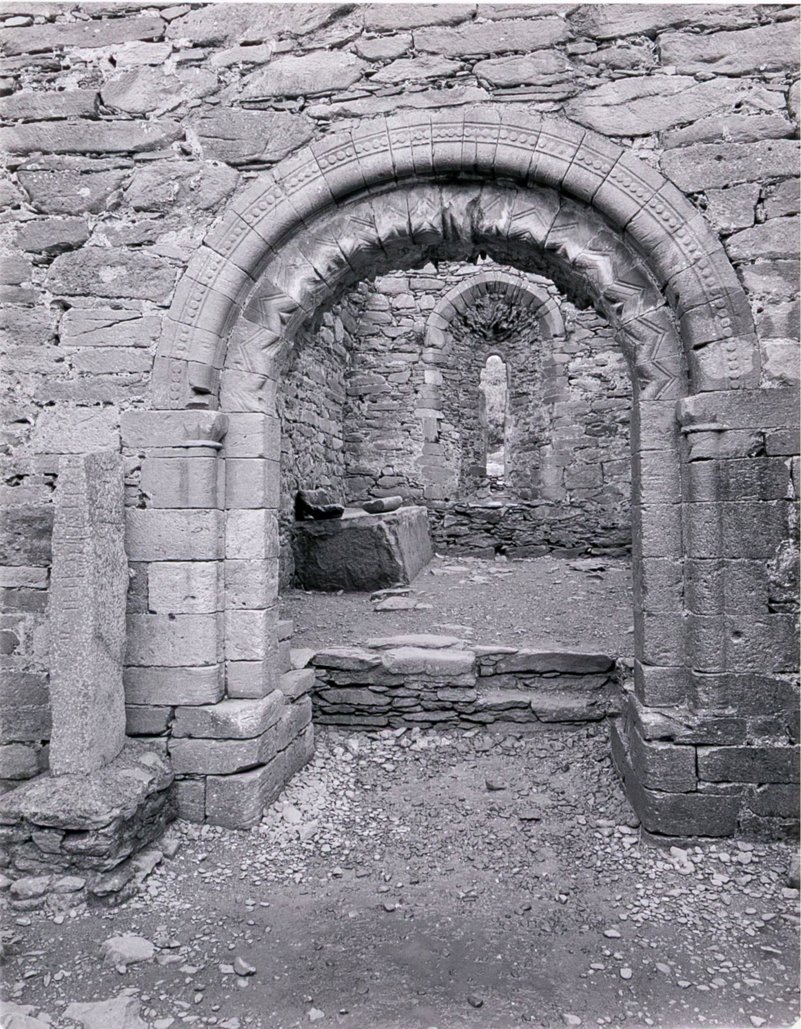 Michael Miller Signed Gelatin Silver Print Of Kilmalkedar Church, Ireland: A wonderful Michael Miller gelatin silver print depicting Kilmalkedar Church, Ireland, with stone architecture featuring arches and columns. Pencil signed and numbered 1/10 on the verso. Unframed. Dim