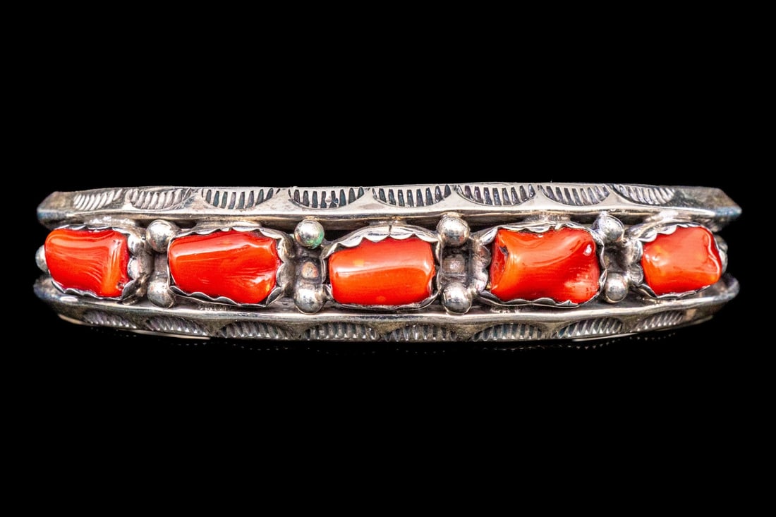 NAVAJO LARRY MOSES YAZZIE STERLING SILVER BEAUTIFUL CORAL SET CUFF BRACELET: This beautiful Navajo sterling silver bracelet is by Larry Moses Yazzie and is a cuff style, featuring a horizontal center line of red coral, punctuated by a border of half moon set chasing, and is fi