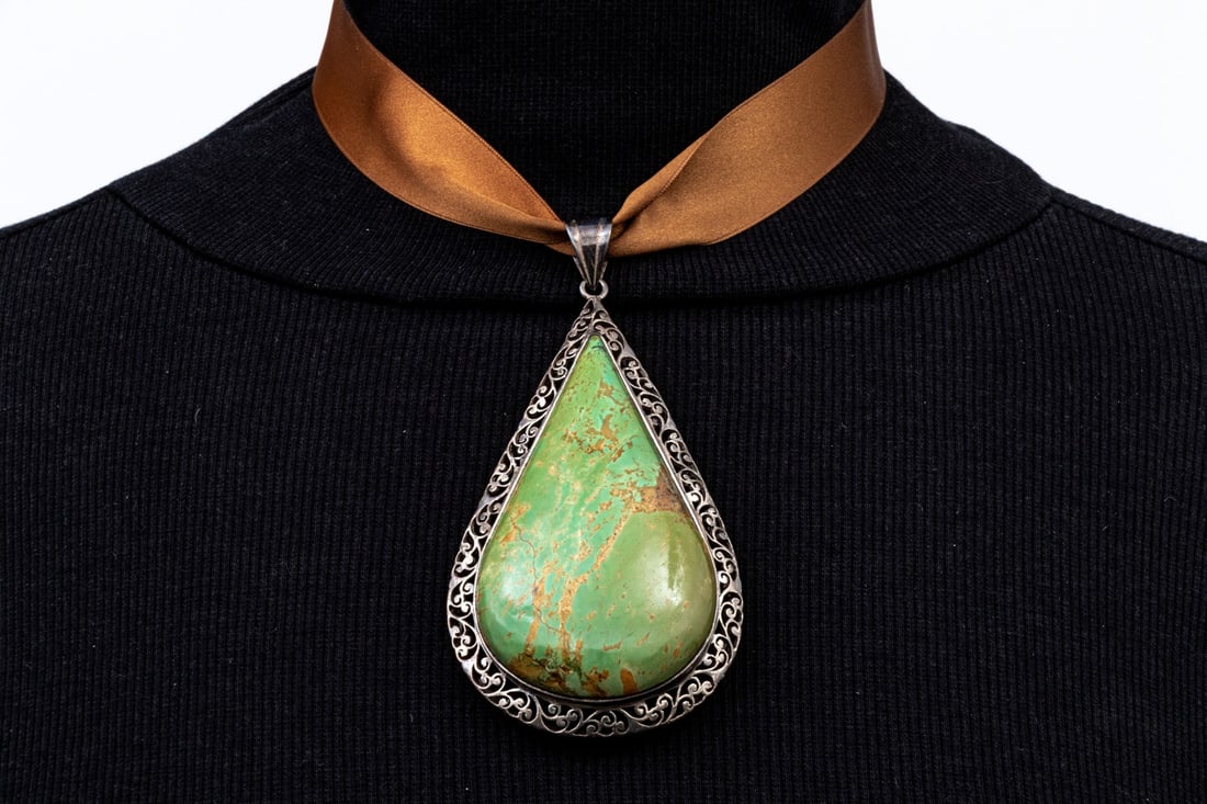 STERLING SILVER PHENOMENAL GIGANTIC GREEN PEAR SHAPED PENDANT, ON RIBBON: This phenomenal pearl shaped pendant has a gigantic 4" form, and features a green pear shaped cabachon turquoise or variscite, bezel set and decorated with a pierced foliate frame. Accompanied by two 