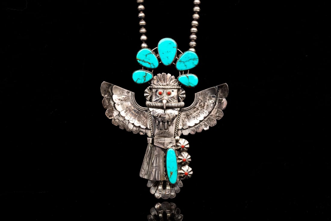 STERLING SILVER STAGGERING ENORNOUS GRAND EAGLE KACHINA NECKLACE, SIGNED: This staggering sterling silver grand Kachina features a winged eagle form, decorated with a beautiful turquoise headdress and studded with coral eyes and decorations. The necklace is displayed on a s