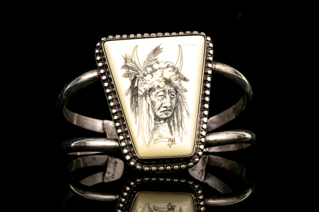STERLING SILVER DISTINCTIVE ETCHED BONE WIDE CUFF BRACELET, SIGNED: This wonderful sterling silver ultra wide cuff bracelet features a trapezoidal form center, set with bone, and decorated with a signed and etched picture of a native American chief, in a horned headdr