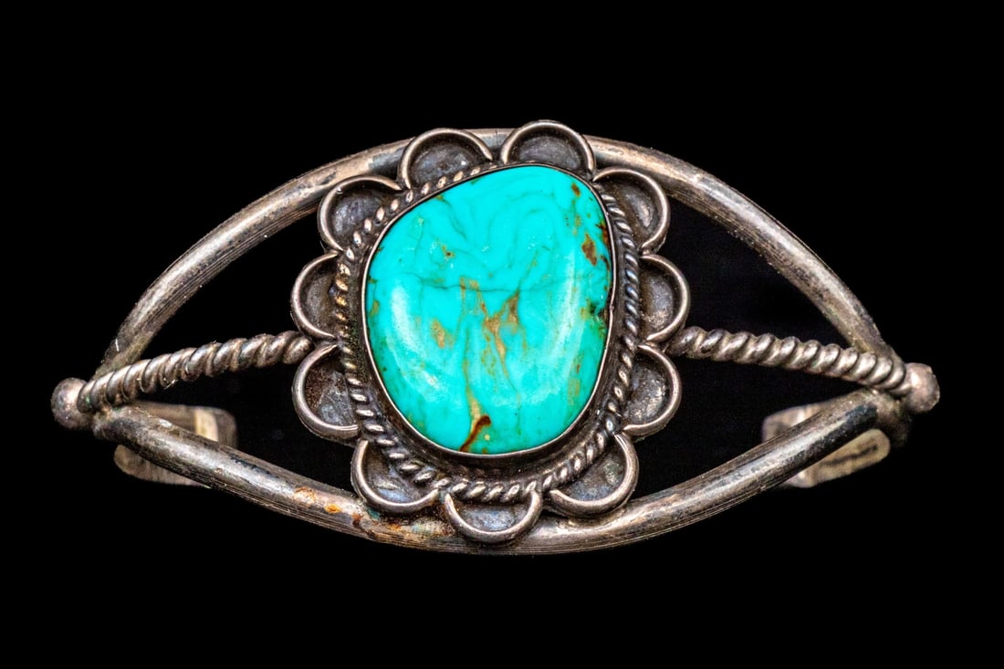 STERLING SILVER DECORATIVE ULTRA WIDE TURQUOISE SET CUFF BRACELET: This decorative sterling silver cuff bracelet features an ultra-wide profile, and is decorated with a flat, freeform cabachon turquoise center, bezel set and finished with a petal motif borders. Finis