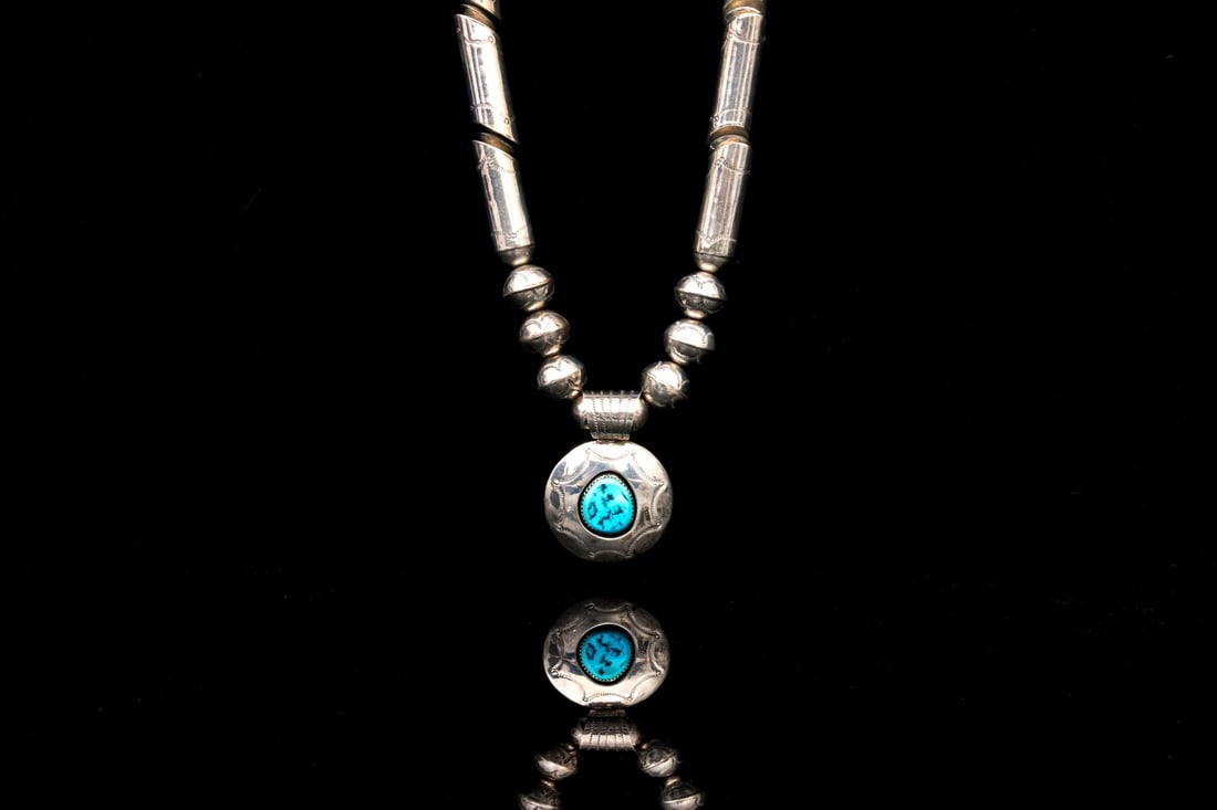 STERLING SILVER UNCOMMON REVERSIBLE TUBULE TURQUOISE SET PENDANT NECKLACE: This unusual sterling silver features patterned, slanted tubule form beads, with patterned edges, leading to seamed globe style beads, and centering a drop drop pendant center, turquoise set and borde