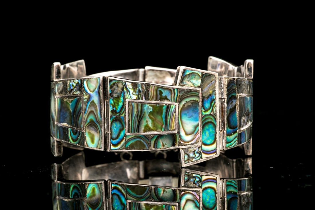 TAXCO STERLING SILVER GOOD-LOOKING BLUE GREEN ABALONE INLAY BRACELET: The beautiful sterling silver Taxco bracelet has a blue and green toned abalone, set into a "T" style link and finished with a hidden box style clasp and a figure eight safetyMarks: Sterling, Taxco Di