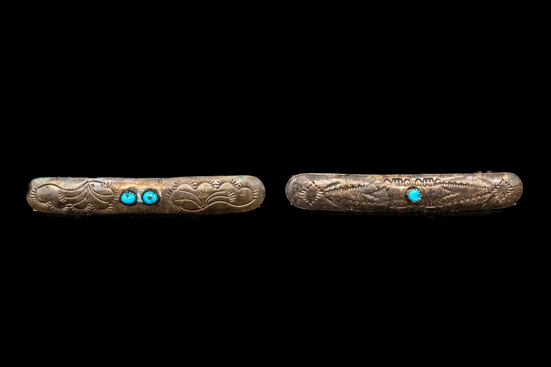 PAIR OF STERLING SILVER SOUTHWESTERN MOTIF CHASED BARRETTES: This pair of sterling silver barrettes feature a rounded, rectangular profile, with a chased patterning and set at the center with tumbled turquoise stones. Finished with stainless steel backs and har