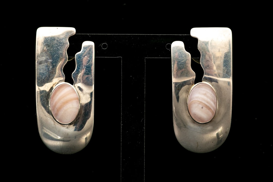 STERLING SILVER AND SHELL SET CONTEMPORARY CHUNKY EARRINGS: These throwback sterling silver earrings have a chunky rounded rectangular profile, with a cutout patterning and decorated with an oval matte shell, bezel set. Finished with posts and plastic clutches