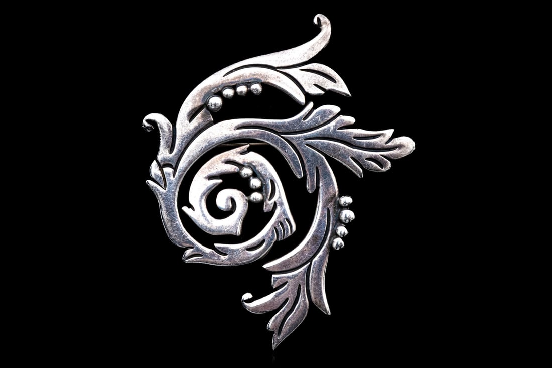 MARICELA TASCO (YSIDRO GARCIA PINA) STERLING SILVER SOUTHWESTERN SWIRL MOTIF BROOCH: This sterling silver Southwestern style large brooch by Ysidro Garcia Pina has a his classic, swirled styling with a feather/foliate patterning and beading Marks: Sterling, Maricela Tasco Dimensions: 