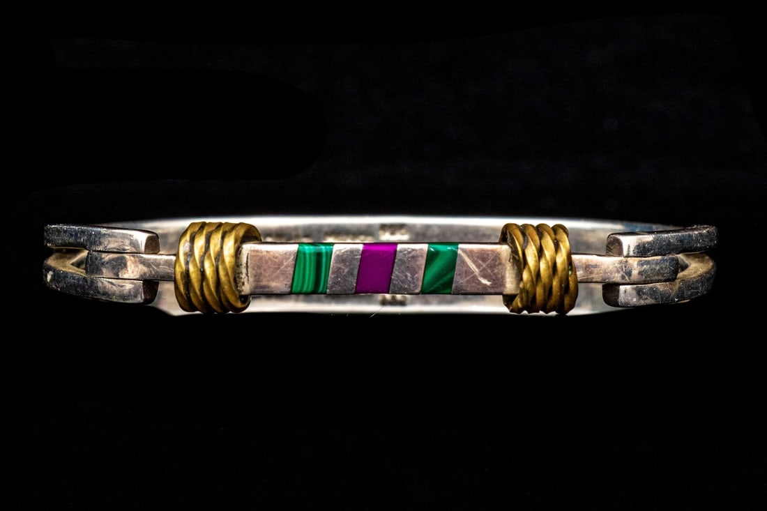 SOUTHWESTERN STERLING SILVER BRASS ROPE AND STONE INLAID BANGLE BRACELET: Sterling silver Southwestern style bangle bracelet, inlaid with charoite and malachite, finished with brass rope style decoration Marks: 925, Mexico Dimensions: 2 5/16" interior diameter x 1/4" wide