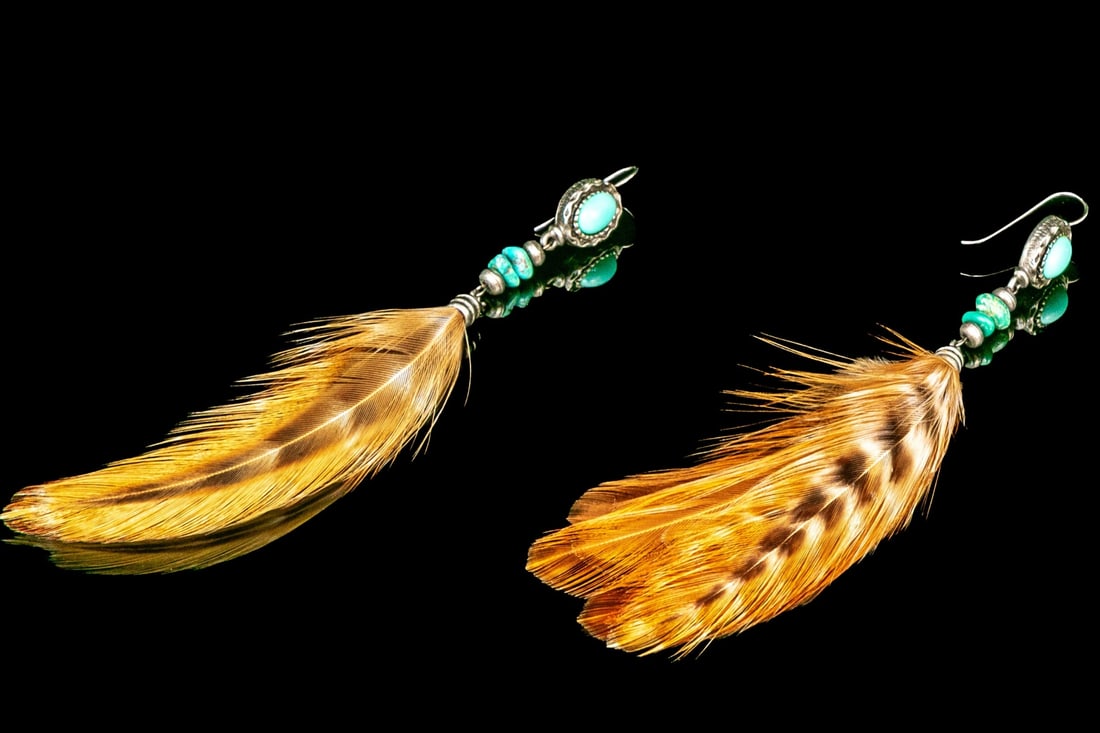 ULTRA-LONG SOUTHWESTERN STYLE GENUINE FEATHER DROP PENDANT EARRINGS: These impactful Southwestern motif ultra long drop pendant earrings feature a turquoise cabachon top, a tumbled turquoise stack, which lead into a genuine brown toned feather. The earrings are