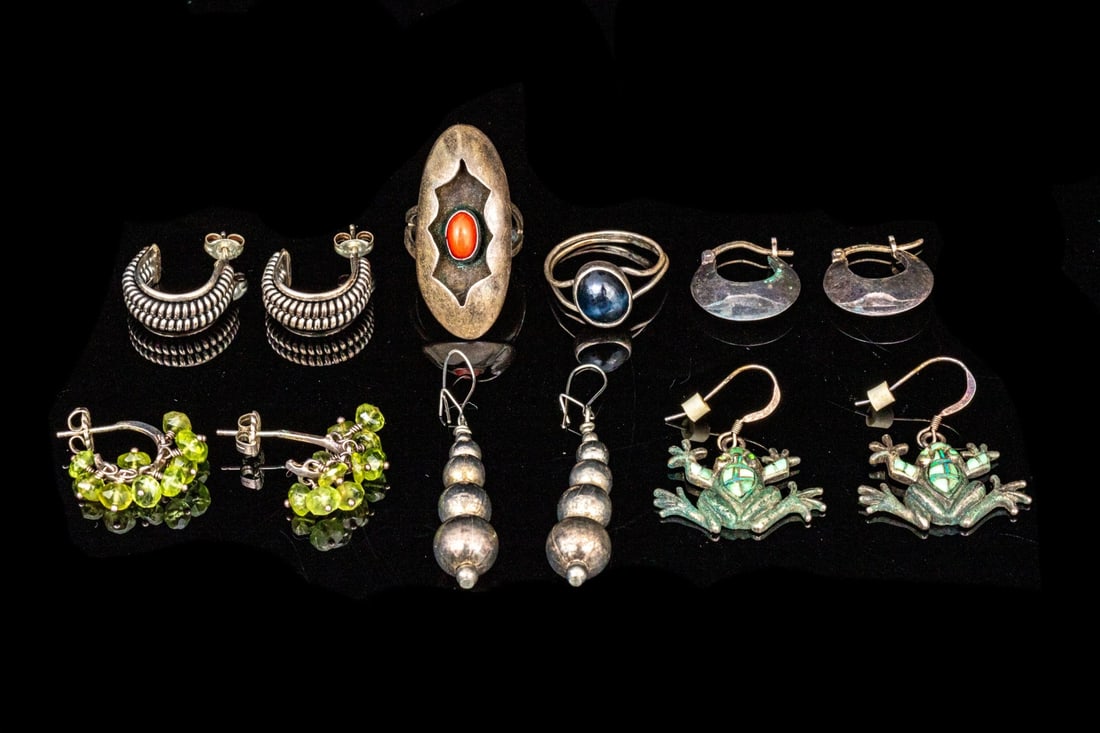 COLLECTION OF STERLING SILVER AND SILVER PLATE JEWELRY PIECES: This eclectic collection of jewelry pieces includes onyx and coral cabochon rings, sizes 6.5, two pairs of hoop earrings, two pairs of drop earrings and one silver plate pair of drop stack earrings Ma