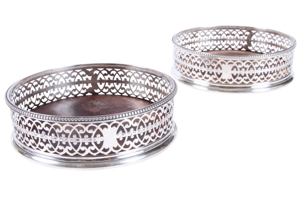 HESTER BATEMAN, PAIR OF SILVER WINE COASTERS: Circular with pierced boarders, mahogany bottoms with ivory medallions, 5" diameter, London Ca. 1777 From the Estate of Thomas and Betty Mellon Evans