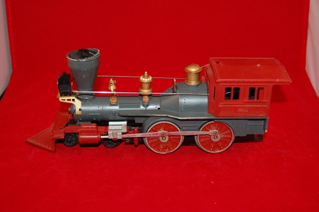 Lionel 1862 Locomotive with three cars 1865, 186,1877: Red and black locomotive. Yellow and brown cars.