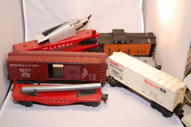 Box of misc. Lionel cars and parts: Here is a nice selection of parts and a few working cars. Caboose, flat cars, plane and box car. You get everything in the photos.