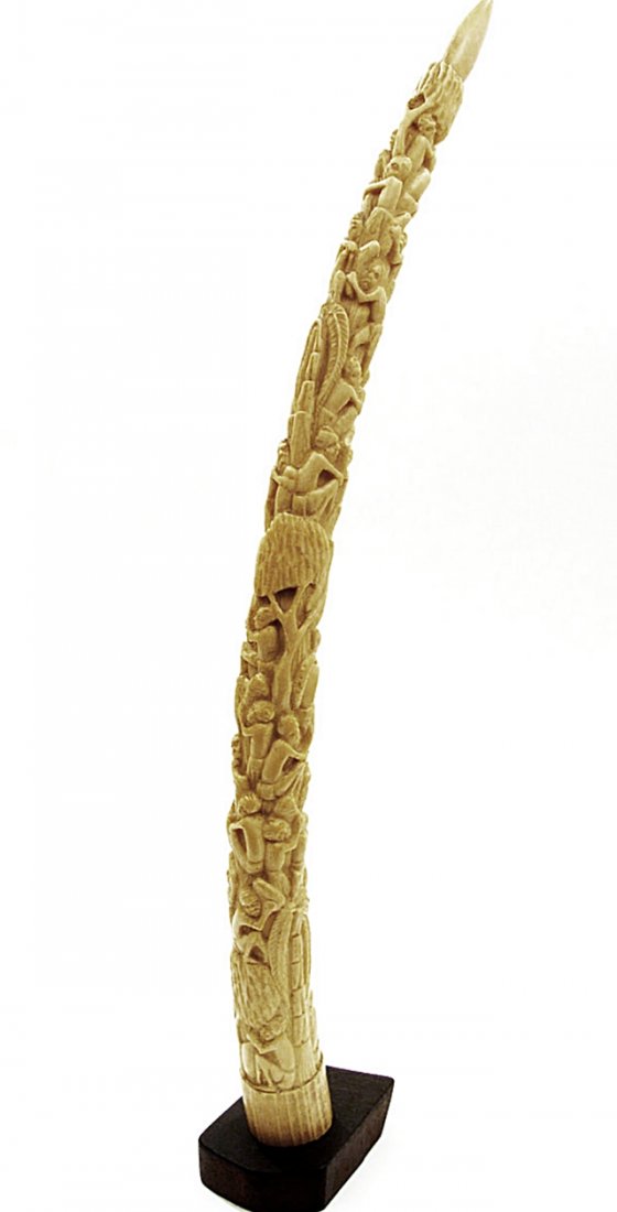 Antique sculpture African elephant ivory, circa 1900: Antique sculpture African tusk elephant ivory profusely hand carved figurative genre scenes, circa 1900. Wood base. 27.60in tusk 1128gr. Please review the legislation and laws of your country in refer