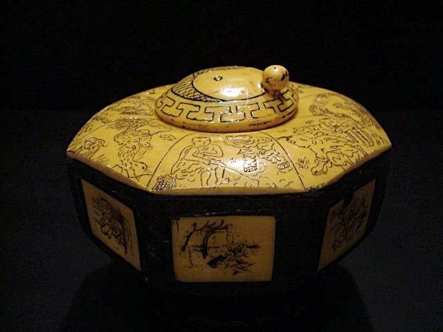 Antique Chinese ink, ebony and bone: Antique Chinese ink, ebony and bone decorated with scenes of everyday life, marks carved into the base. 4.75in diameter.