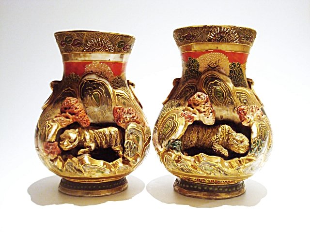 Antique pair Japanese Satsuma Vases: Antique pair Japanese Satsuma Vases, probably gosu blue, porcelain carved with of a cave and a crouching tiger, with a scene of sea and mountains surrounded by vegetation. Painted with fine gold and m