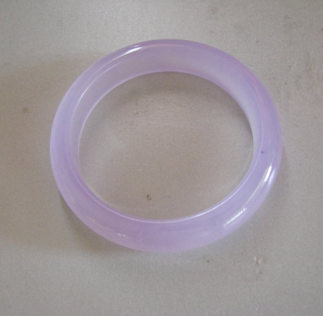 Natural Jadeite Jade Bangle JBA-B Size 6.75: Natural Jadeite Jade Bangle Clarity: JBA-B, Color: Lavender Transparency: Semi -Transparent Shape & Cut: Solid Jade Band Haft Round Jade Finish: High Polish Remarks: Genuine Jadeite Quality: Excellent