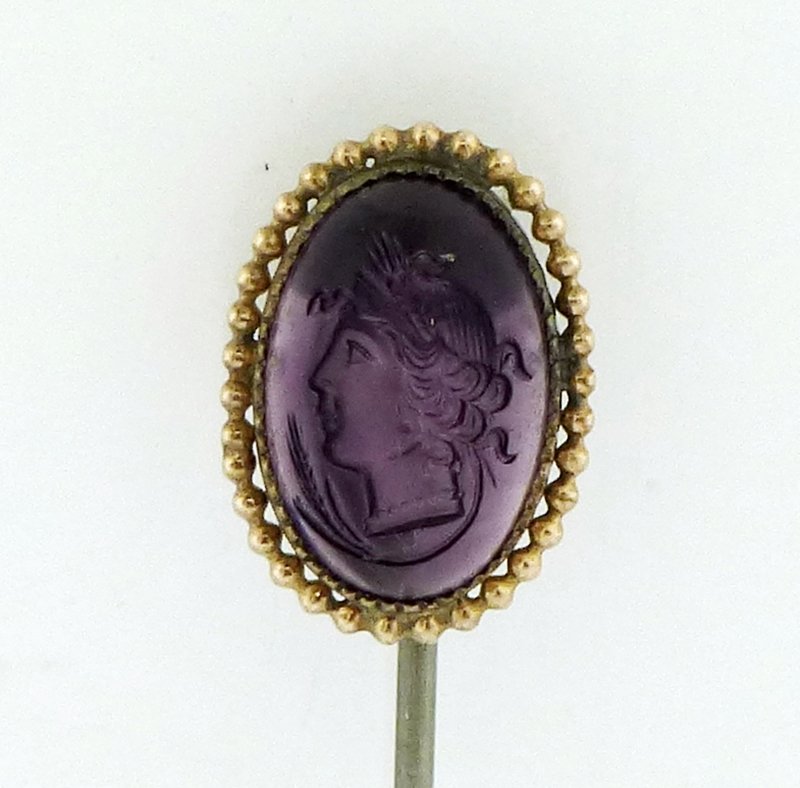VICTORIAN AMETHYST STONE INTAGLIO STICK PIN: Here is a stunning antique intaglio work done on a bezel set amethyst-colored stone which is set in gold-tone metal, not tested. The pin itself measures 2.65" tall. The stone has not been tested due t
