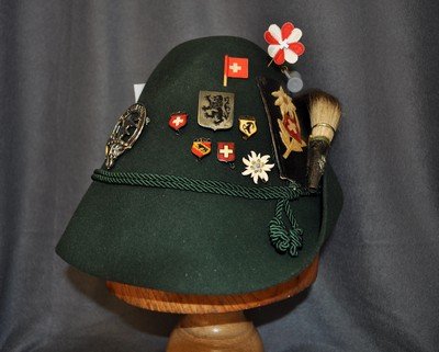 SWISS CLOTH ALPINE HIKERS CAP W/ SCARCE BADGES XJ: We are very pleased to offer this 1960s vintage Swiss alpine hikers hat, with its original feather band insert. Over the years, numerous other scarce hat badges have been added. Some of these include 