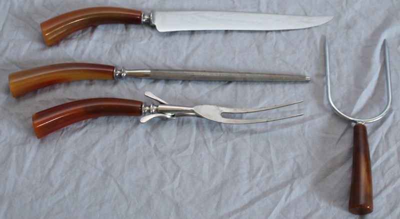 4 PC VINTAGE BAKELITE CARVING SET: 4 piece carving set with Bakelite handles. Knife, fork, prong, sharpener. Knife blade reads stainless universal resistain. For Shipping Weight : 1 Pd Measurements: 12x4x4