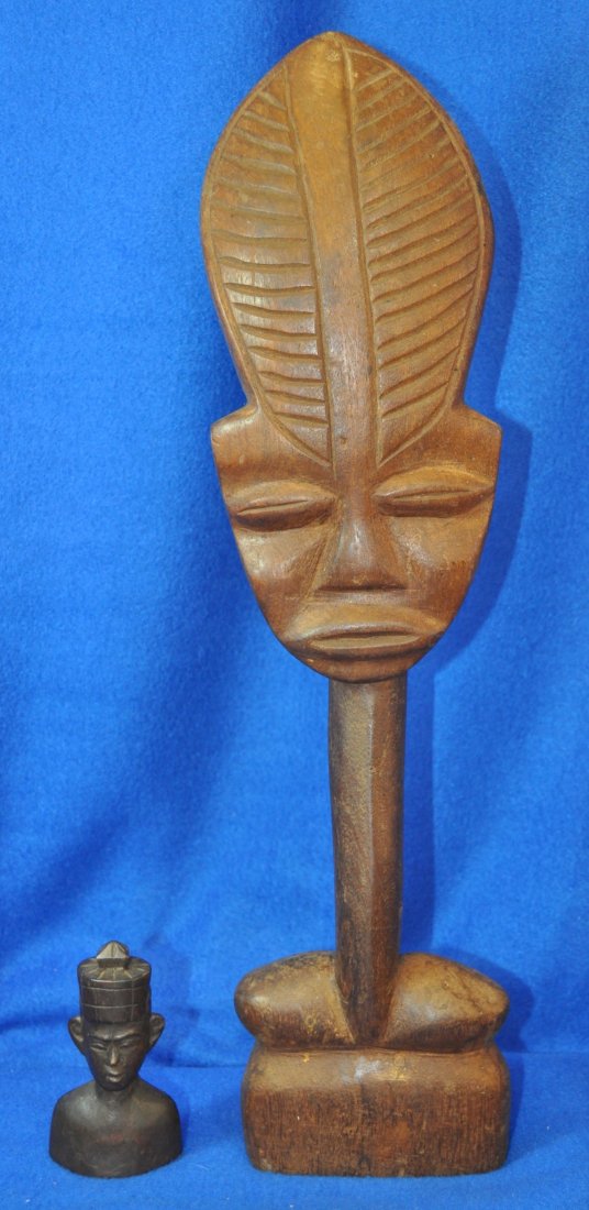 1970s WOODEN HD CARVED AFRICAN FEATHRE MASK FIGURINE XT: We are pleased to offer the long & the short of it, in the form of these two 1970s vintage hand carved wooden African pieces. The tall light wood facial mask on the pole with feather stands a prominen