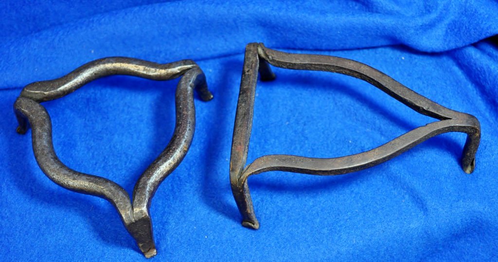 LOT 2 ANTIQUE HAND FORGED SAD IRON TRIVETS XC: Lot 2 Antique Trivets , on the right a hand forged sad iron trivet , curled toes , circa late 1800's and on the left , the smaller one, hand forged steel , curled toes , circa early 1900, when suspend