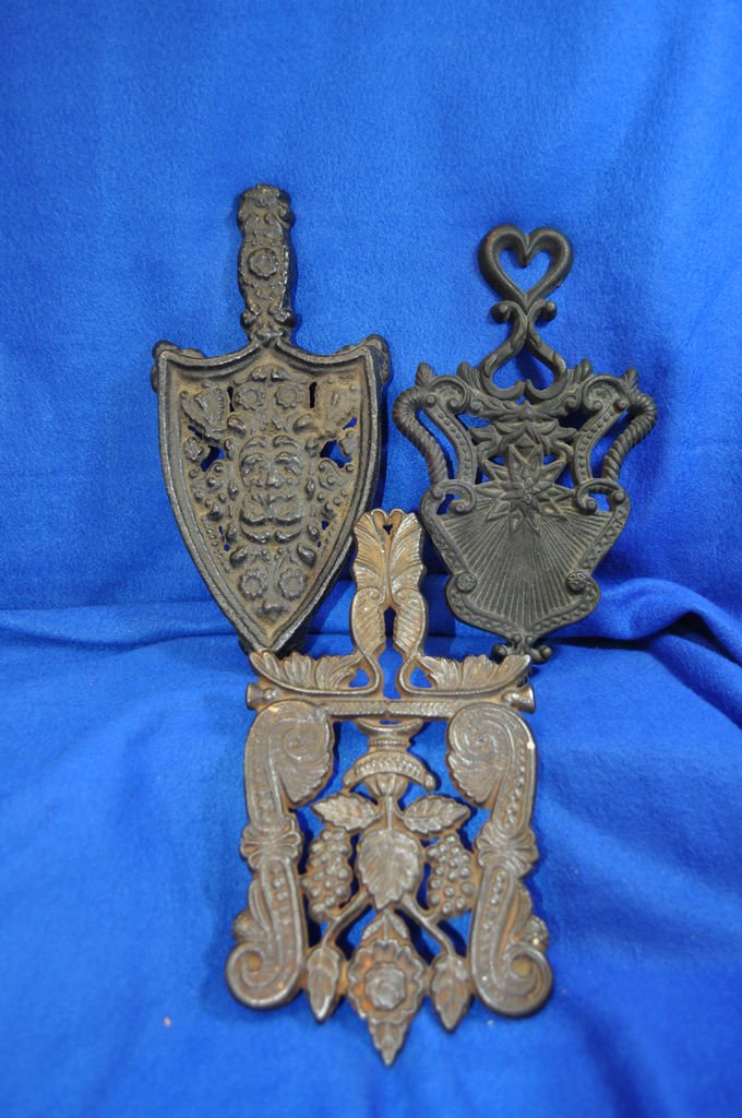 LOT 3 ANTIQUE TRIVETS CAST IRON SAD IRONS XC: Offered for your consideration this Lot of 3 Antique Cast Iron Trivet's for Sad Iron's , in the first picture the trivet on the left top, shows some age wear on feet, Flowers and Heart Motif , one ver