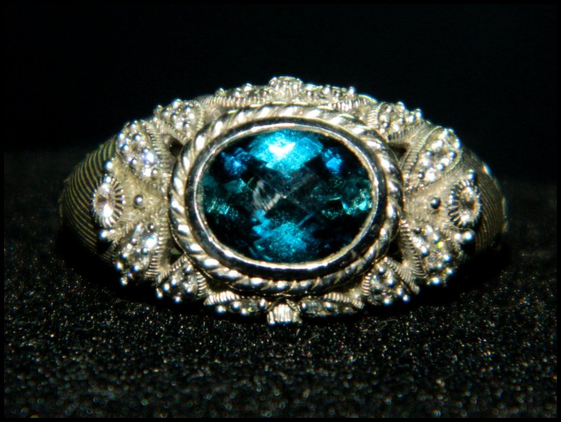 JUDITH RIPKA BLUE TOPAZ DIAMONIQUE STERLING RING XR: We are delighted to offer this stunning Judith Ripka 925 Sterling Silver Ring with a faceted Blue Topaz stone. This ring features cutout sides liberally pave set with high quality Diamonique crystals.