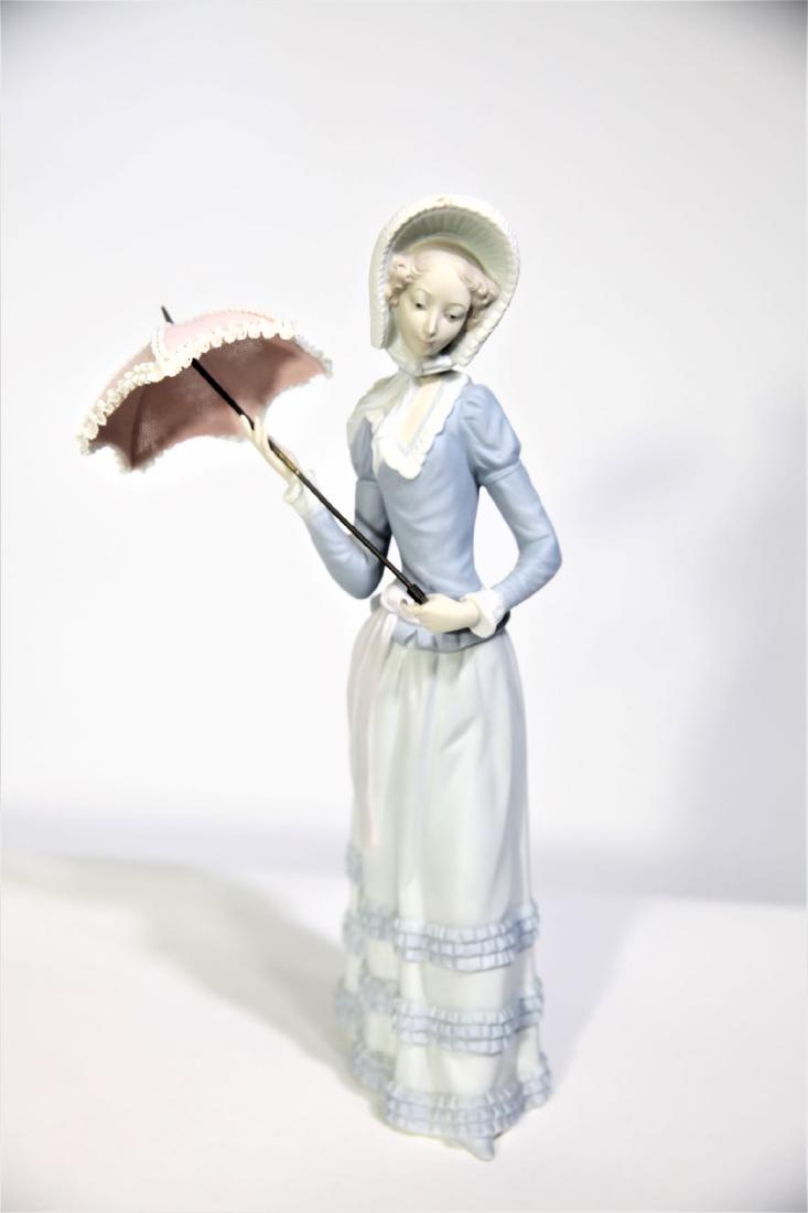 Lladro "Little Lady" Porcelain Woman with Umbrella: Lladro "Little Lady" Porcelain Woman with Umbrella Figurine, hand made in Spain. Based in Tavernes Blanques, Valencia in Spain, LladrÃ³ produces exquisite porcelain figurines. The company was founde