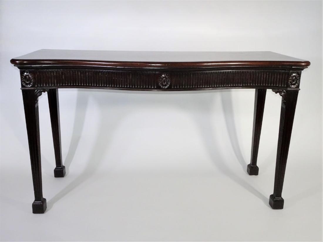 George III Mahogany Side Table: Serpentine top and fluted frieze on fluted square legs, top replaced. Size: 35 in. H, 61 1/2 in W, 24 1/2 in Depth. Provenance: This item originally comes from the collection of a Newport, RI. mansion