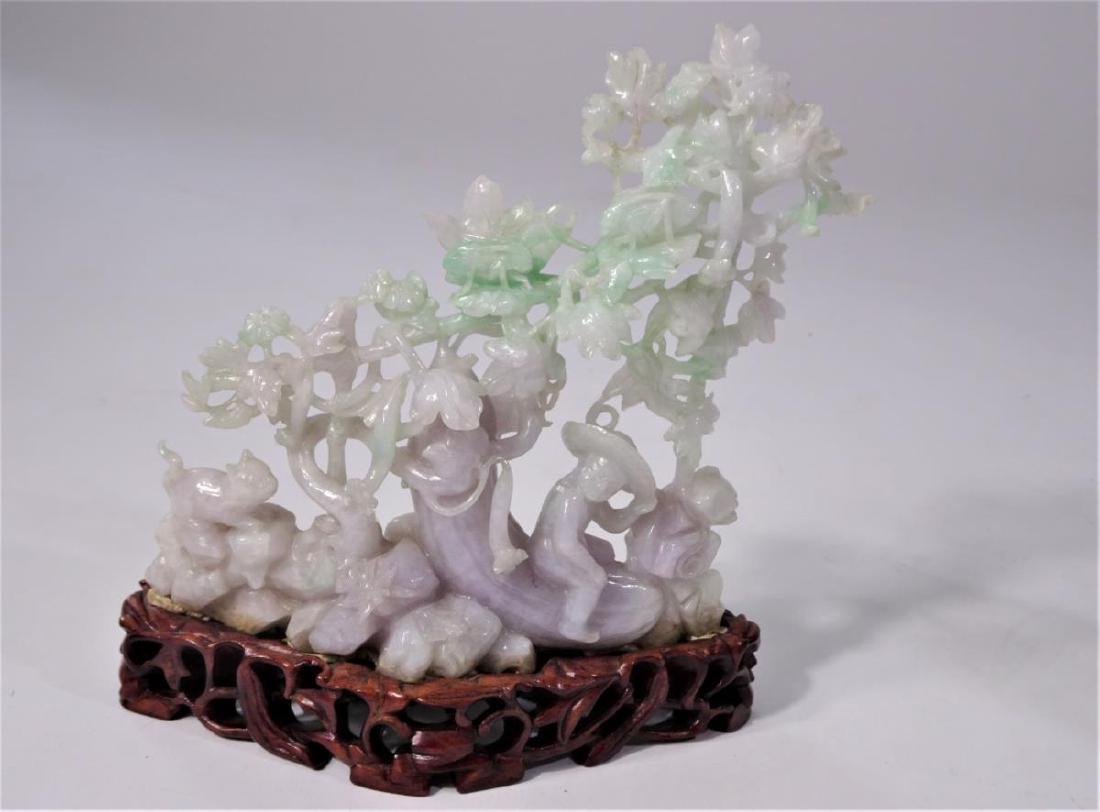 Chinese Jade Carving on Wooden Base: Size: 8 x 8 in. Ornate Design on the jade and the base. Jade figure includes man, cat, flowers and plants.